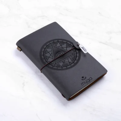 Sort notesbog med "Tarot øje" og klar Quartz krystal