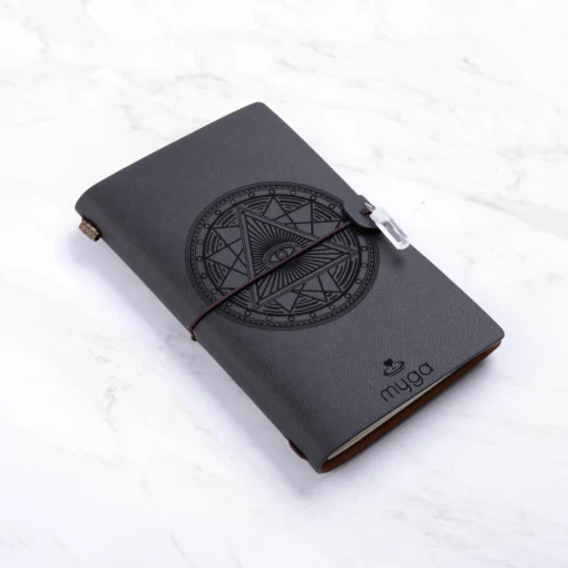 Sort notesbog med "Tarot øje" og klar Quartz krystal